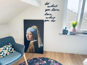 Ein Zimmer mit einem Bild eines Mädchens mit Kopfschmuck. in der Unterkunft B&B Huize Van Damme in Nieuwpoort