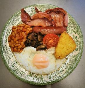 a plate of breakfast food with eggs bacon beans and toast at The Cedars Ashby in Ashby de la Zouch