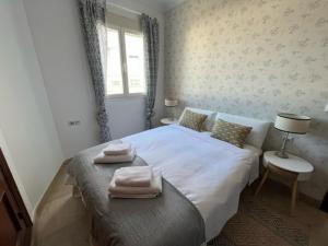 a bedroom with a large bed with towels on it at Amador Apartamento Familiar Centro PARKING Amador de los Rios in Seville