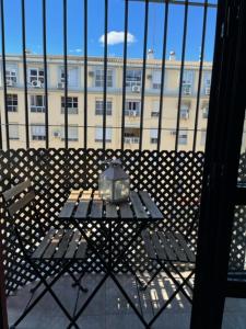 una mesa en un balcón con un edificio en el fondo en Amador Apartamento Familiar Centro PARKING Amador de los Rios, en Sevilla