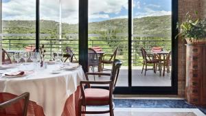 een eetkamer met tafels en stoelen en een balkon bij Hospedium Hotel Doña Mafalda de Castilla in Plasencia