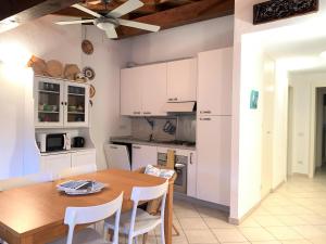 uma cozinha com uma mesa de madeira e armários brancos em Appartamento Centro Storico em Levanto