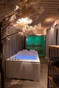 eine Badewanne in einem Zimmer mit Blumen an der Decke in der Unterkunft Capsule Thailande I Sauna I Balnéo I Console I jeux en bois I Cinéma I cour intérieure in Trith-Saint-Léger