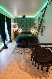 a bedroom with a bed and a hammock in a room at Capsule Thailande I Sauna I Balnéo I Console I jeux en bois I Cinéma I cour intérieure in Trith-Saint-Léger