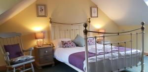 um quarto com uma cama de dossel e uma cadeira em Heart of Glencoe Holidays em Glencoe