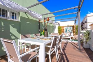加的斯的住宿－Genteel Home Mercado Central Terrace，木制甲板上的白色桌椅和遮阳伞