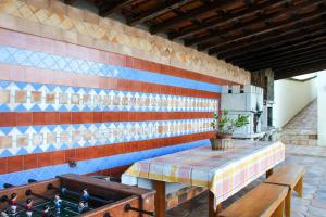 a table and benches in a room with a colorful wall at Moradia do Paço - Piscina Privada in Arco de Baúlhe