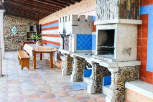 a patio with an outdoor oven with a table at Moradia do Paço - Piscina Privada in Arco de Baúlhe