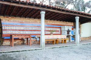 a pavilion with a table and benches in front of a building at Moradia do Paço - Piscina Privada in Arco de Baúlhe