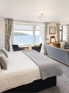 a bedroom with a large bed with a view of the ocean at Gwbert Hotel in Cardigan