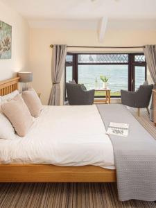 Un dormitorio con una gran cama blanca y una ventana en Gwbert Hotel, en Cardigan