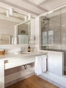 Baño blanco con lavabo y espejo en Hotel Casa Nereta en Cadaqués