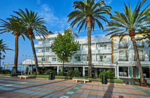 a building with palm trees in front of it at Hotel Balcón de Europa in Nerja