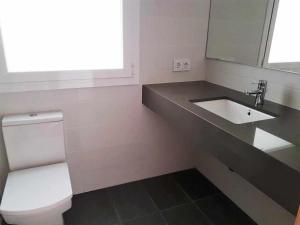a bathroom with a white toilet and a sink at Roses Casc Antic SL Avgda de Rhode in Roses +14 photos