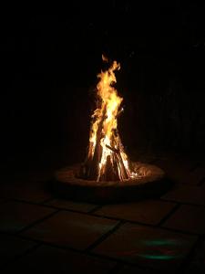 una hoguera en la oscuridad con llamas en Davis Farm House, en Maraiyūr
