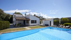 a villa with a swimming pool in front of a house at Can Seguinot in El Port