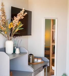 a kitchen with a table with a vase of flowers at B&B Sole Mare Luna in Lu Lioni