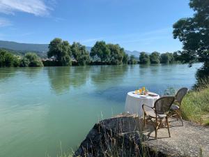a table with two chairs sitting next to a river at Au bord de l’eau in Orpund