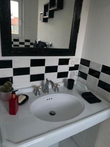 a white sink in a bathroom with a mirror at Au bord de l’eau in Orpund