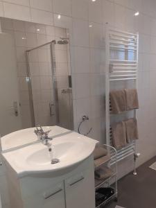 a white bathroom with a sink and a shower at Alsdorf 3 in Alsdorf