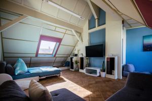 a living room with a couch and a tv at Rooftop Penthouse Karlsruhe in Karlsruhe