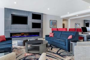 sala de estar con sofás azules y chimenea en Comfort Suites McDonough Atlanta South, en McDonough