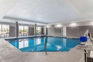 a large swimming pool with blue water in a building at Comfort Suites McDonough Atlanta South in McDonough