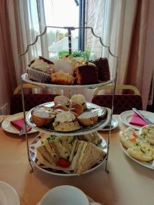 a table with three tiered plates of food on it at Vallum House in Carlisle