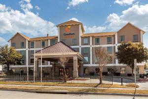 a hotel with a fence in front of it at Comfort Suites Waco Near University Area in Waco