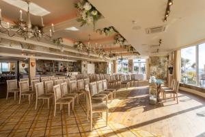 a room with a row of chairs and a bar at Roslin Beach Hotel in Southend-on-Sea