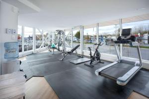 a gym with treadmills and ellipticals in a room with windows at Quality Inn in Quebec City