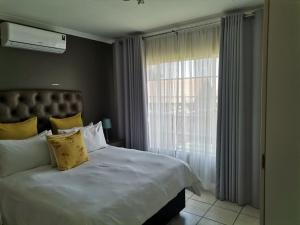 a bedroom with a large bed and a window at Town House at The Reeds in Centurion