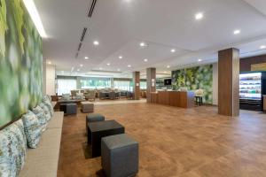 a lobby with a waiting area with couches and chairs at Wyndham Garden Orlando Airport - Free Airport Shuttle in Orlando