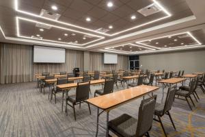 a conference room with tables and chairs and a screen at Wyndham Garden Orlando Airport - Free Airport Shuttle - PARK N' FLY Available in Orlando +38 photos