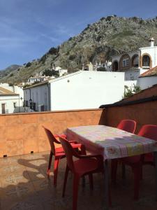 a table and chairs on a balcony with a mountain at El Rinconcito de Nadia in Benaocaz