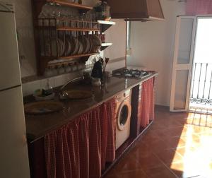 a kitchen with a stove and a washing machine at El Rinconcito de Nadia in Benaocaz