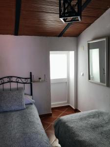 貝瑙卡斯的住宿－El Rinconcito de Nadia，一间卧室设有两张床、一个窗口和镜子