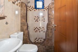 a bathroom with a toilet and a sink and a shower at Alexandros by the Beach - Serifos in Livadakia