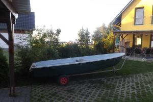 un barco verde estacionado en un patio junto a una casa en Ferienhaus am Saaler Bodden, en Neuendorf