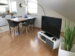 ein Wohnzimmer mit einem Tisch und einem TV auf einem weißen Schrank in der Unterkunft Ferienapartment Alma in Erfurt