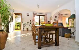 eine Küche mit einem Tisch und Stühlen sowie ein Wohnzimmer in der Unterkunft 3 Bedroom Stunning Home In Saint Quentin La Poter in Saint-Quentin-la-Poterie