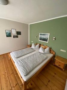 a bedroom with a large bed with green walls at Gasthaus Holdermühle in Creglingen