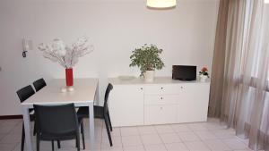 comedor con mesa y mesa y sillas blancas en Rosa dei Venti, en Lignano Sabbiadoro 12 fotos más