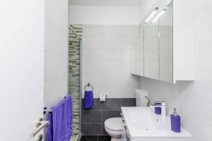 a white bathroom with a toilet and a sink at Dubrovnik: Apartment Quiet Corner in Dubrovnik