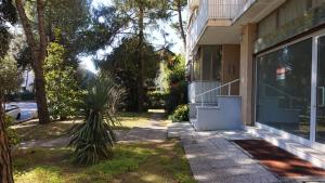 una casa con una palmera delante de ella en Rosa dei Venti, en Lignano Sabbiadoro