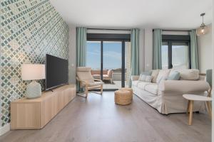 ein Wohnzimmer mit einem Sofa und einem TV in der Unterkunft iloftmalaga Pacífico - Edf. Oceanía in Málaga