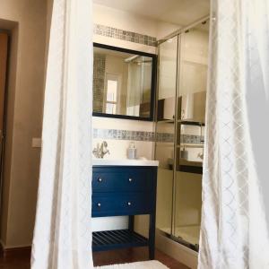 ein Badezimmer mit einem blauen Waschbecken und einer Dusche in der Unterkunft Gaïa, maison d'hôtes Verdon, vue féerique in Blieux