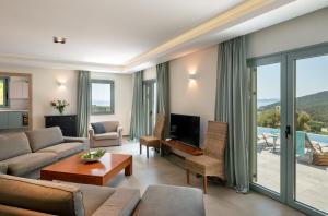 a living room with a couch and a tv at Villa Benedetta Unique Privacy And Sea View in Sivota