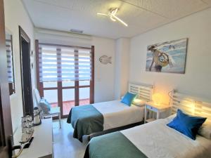a hotel room with two beds and a window at Nueva Andalucia - Penthouse in Marbella