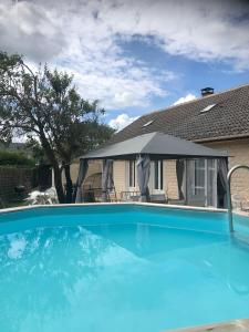 duży niebieski basen z namiotem w obiekcie Villa de 4 chambres avec piscine privee jardin clos et wifi a Saint Martin Longueau w mieście Saint-Martin-Longueau
